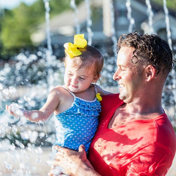 father and daughter playing in pool